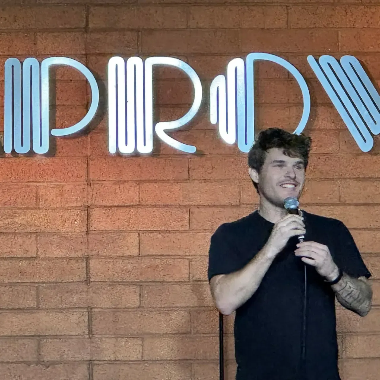 Andrew performing stand-up onstage